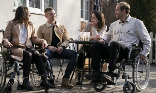 Groupe d'amis discutant autour d'une table.